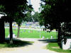 Blick durch den Zaun zum Spielfeld, im Hintergrund der Gsteblock